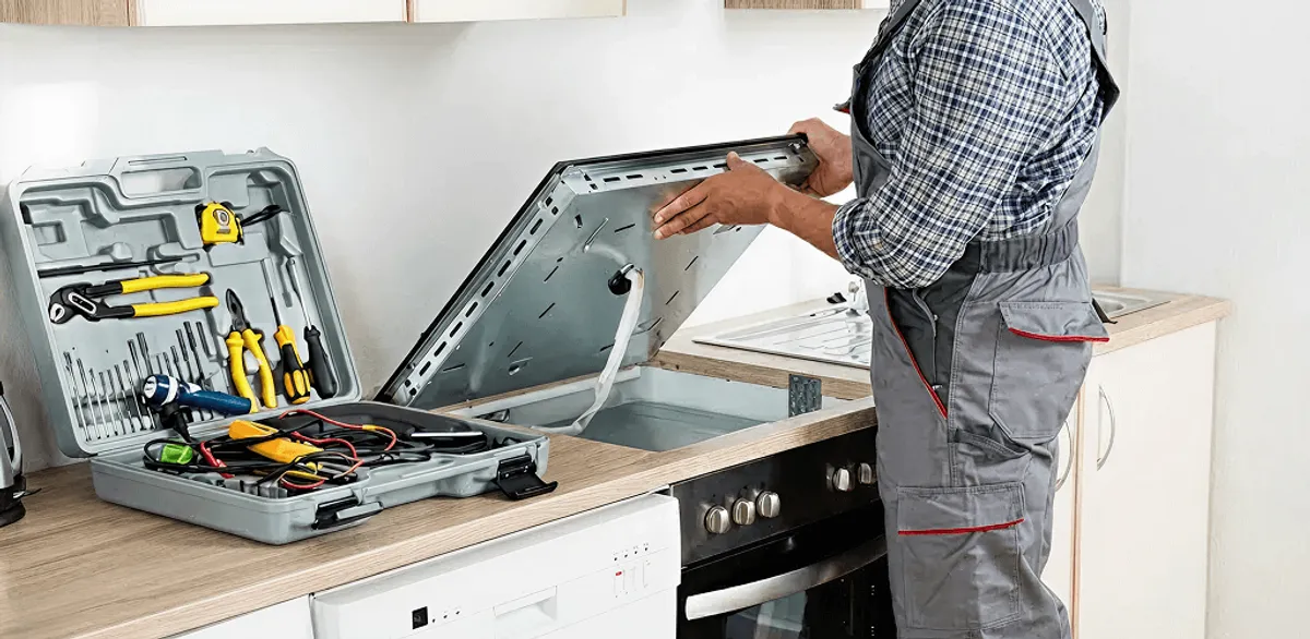 Handyman repairing a cooktop and checking wiring connections in Dayton, OH