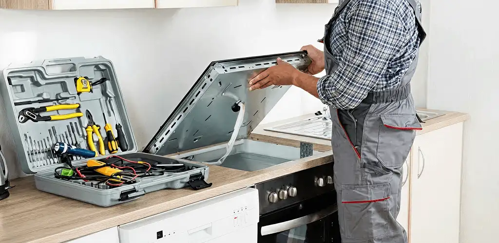 Handyman repairing a cooktop and checking wiring connections in Dayton, OH
