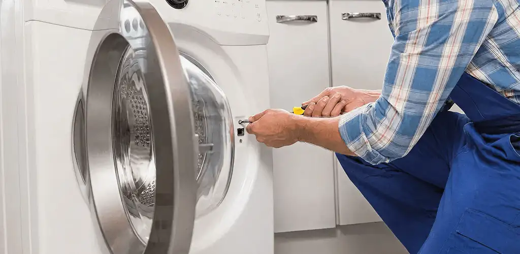 Handyman repairing a clothes dryer and checking electrical connections in Dayton, OH