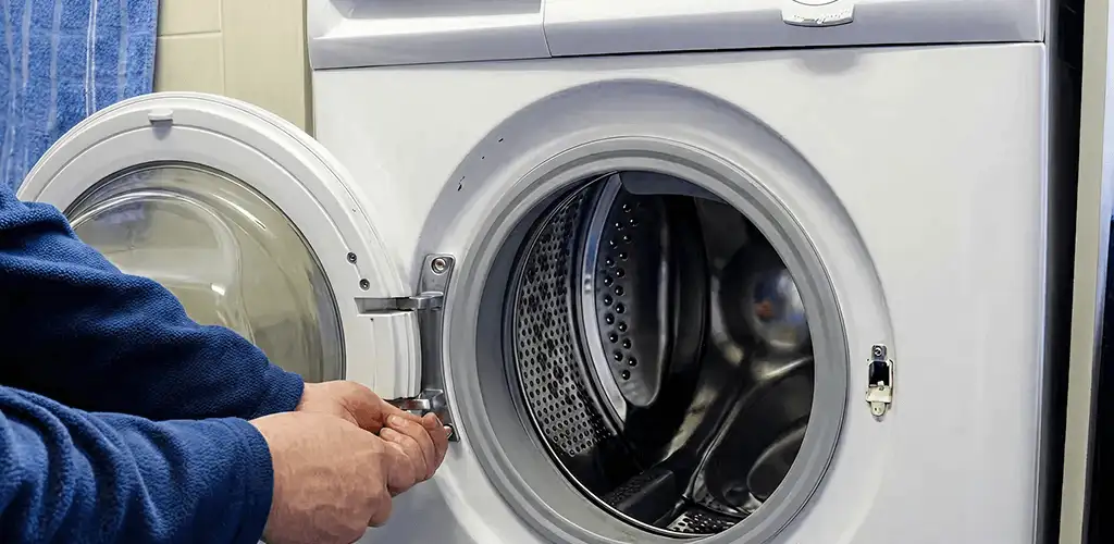 Washing machine repair handyman checking a front-load washer door and latch in Dayton, OH