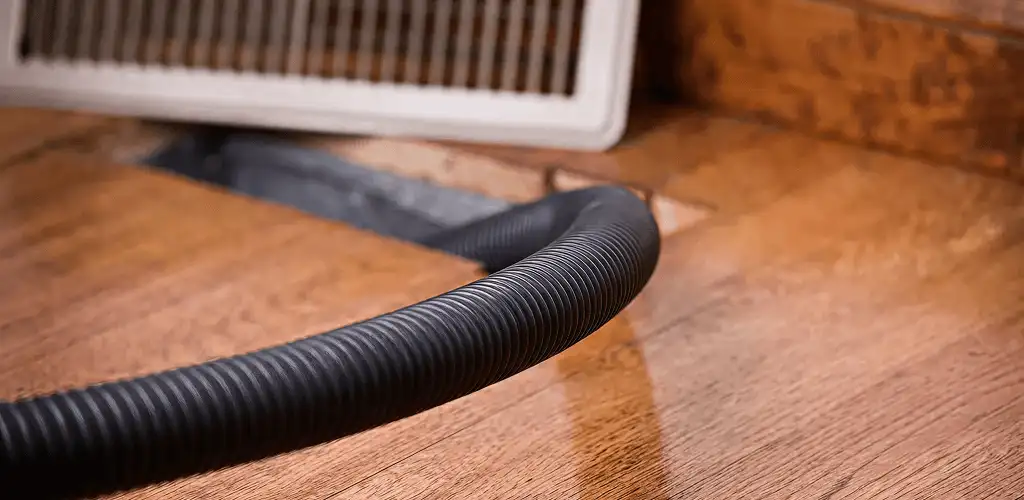 Air duct cleaning hose inserted into a floor vent for ductwork cleaning in Dayton, OH