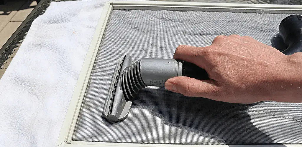 Window screen repair cleaning and fixing a damaged screen mesh in Dayton, OH